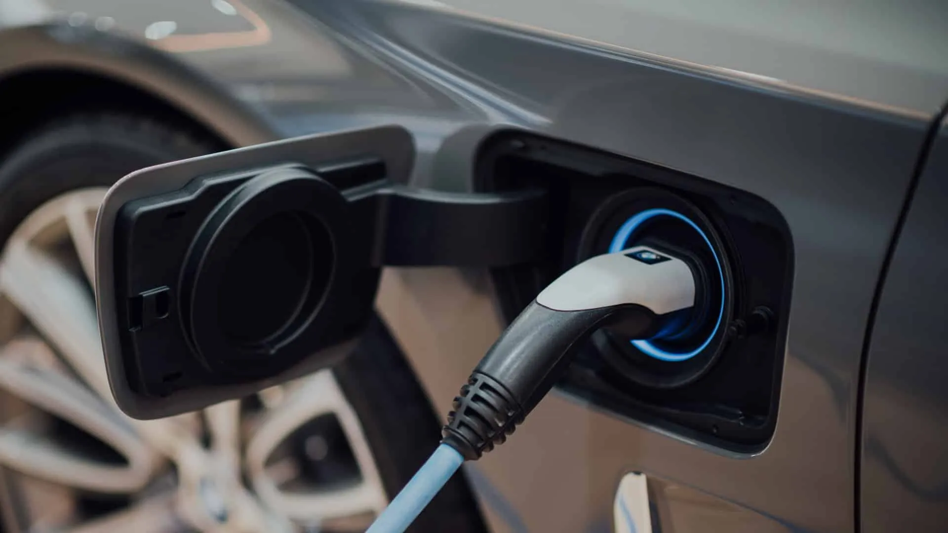 Hotel-Restaurant-Schwanen-Koengen-E-Ladestation Ladekabel an Elektroauto-Ladeanschluss in Nahaufnahme, seitlich des Autos, mit geöffneter Ladeabdeckung.